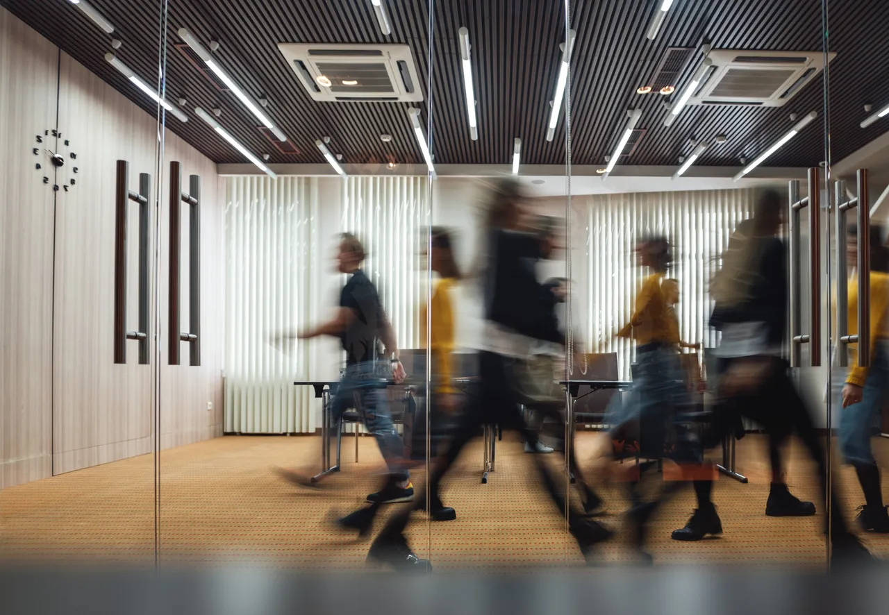 Group of office employees at coworking center. Business people walking at modern open space. Motion blur. Concept