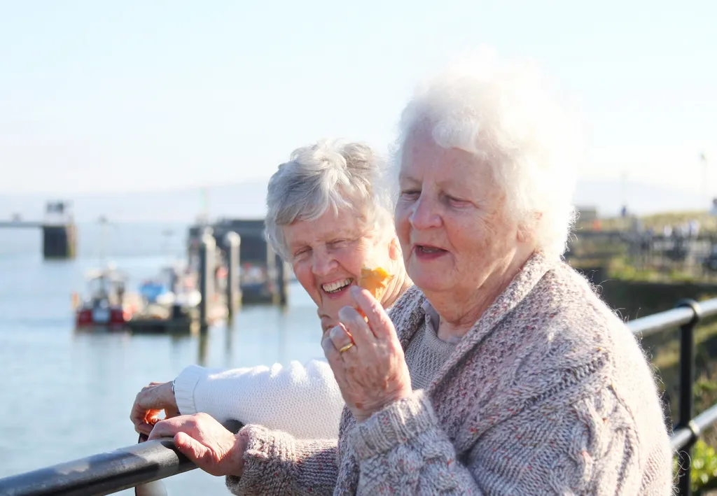 Two senior women outdoors, sisters enjoying together